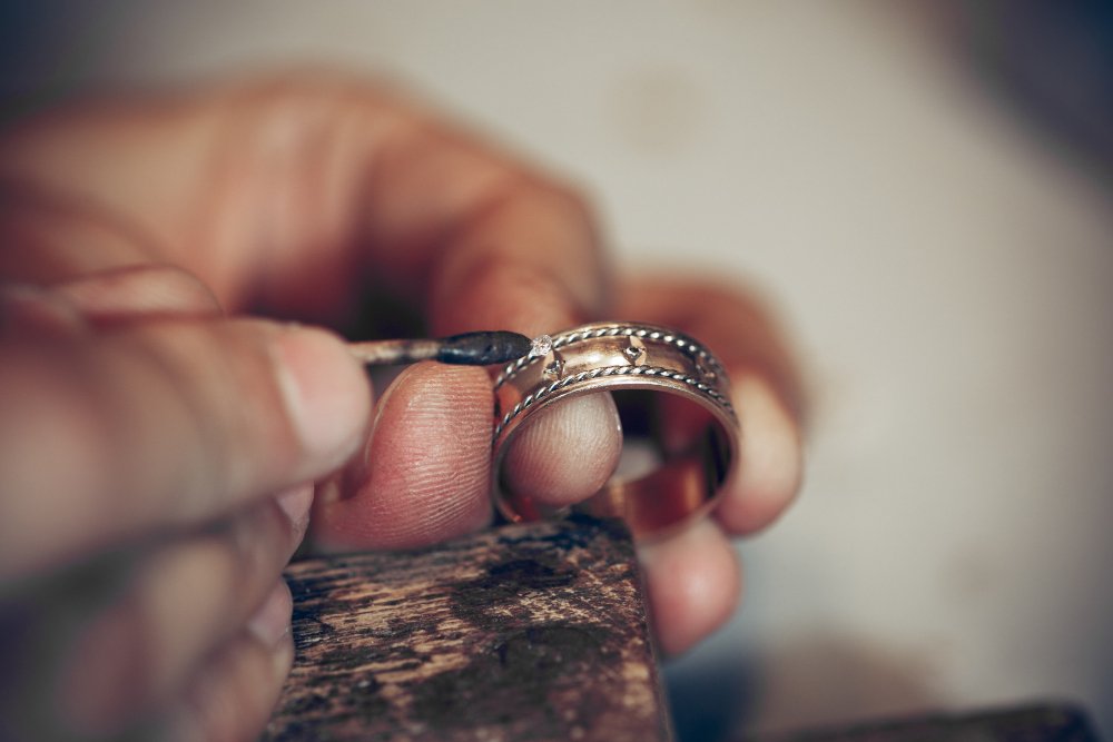 Susie's Jewelry Repair a person's hand holding a gold ring
